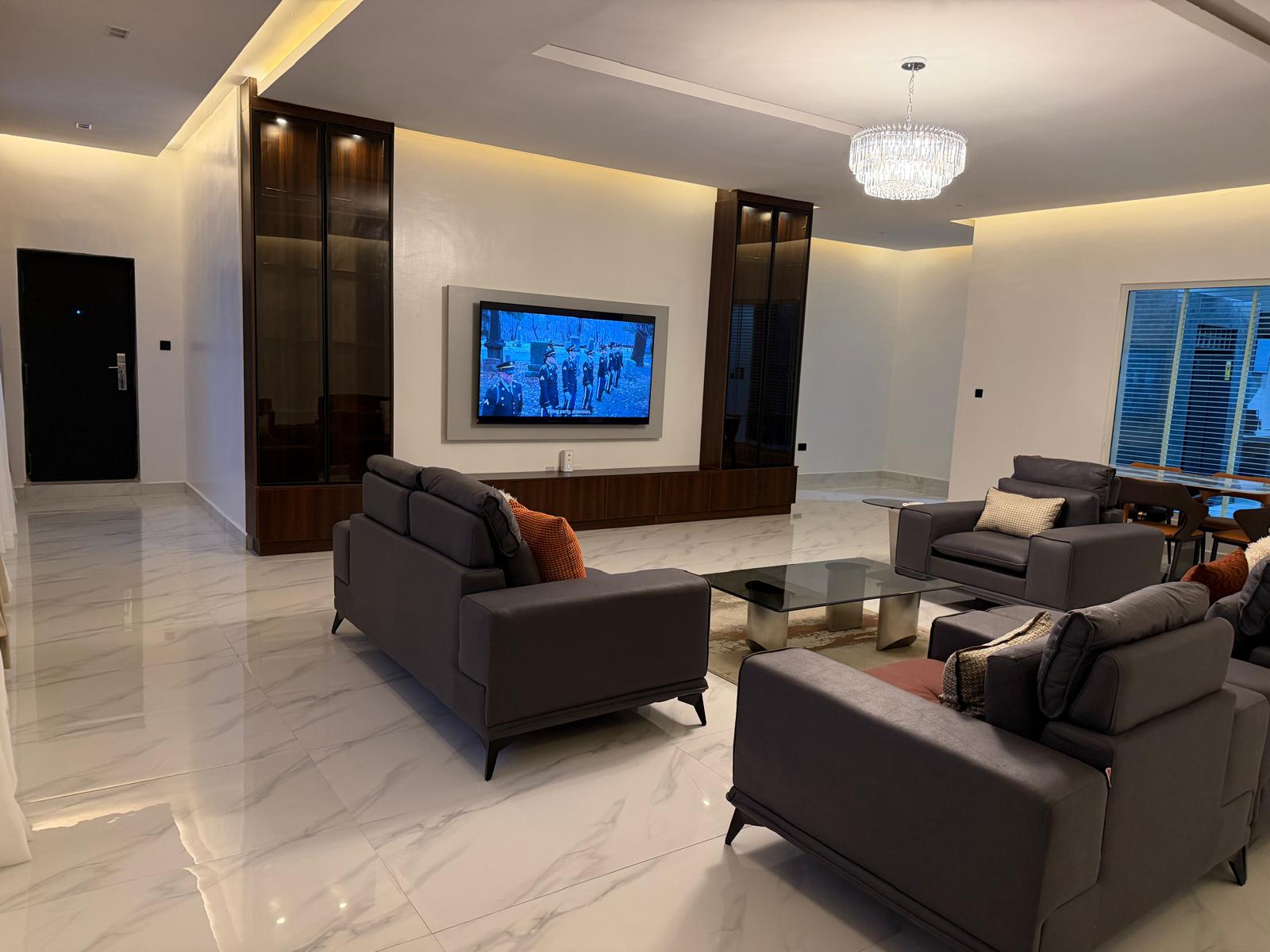 Lower Level Lounge — designer sofa seating, media wall and staircase
